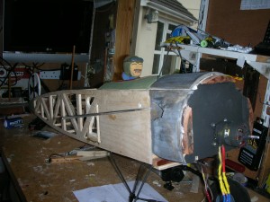 Forward hatch and cockpit in place, primer coat of silver; first coat black paint inside cowl - hardwood mounting blocks top and sides.